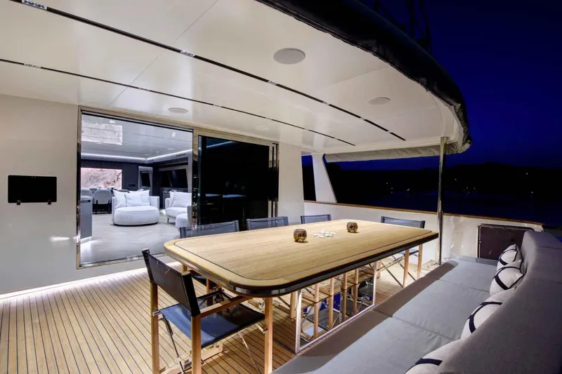  Yacht Photos Pics Luxurious 1985 Heesen Pleasure Vessel with elegant outdoor dining area at night.