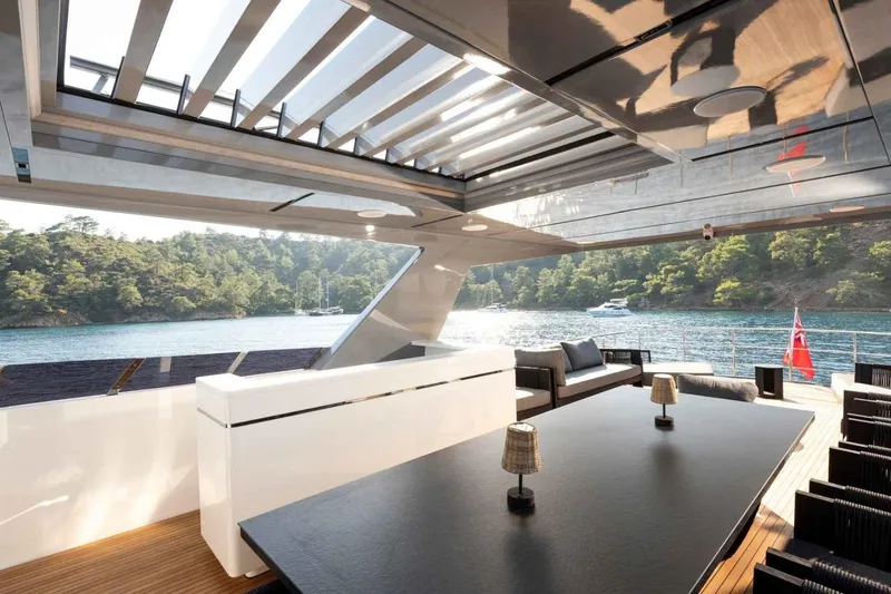  Yacht Photos Pics Luxurious 1985 Heesen Pleasure Vessel with modern deck, scenic water view, and elegant seating.