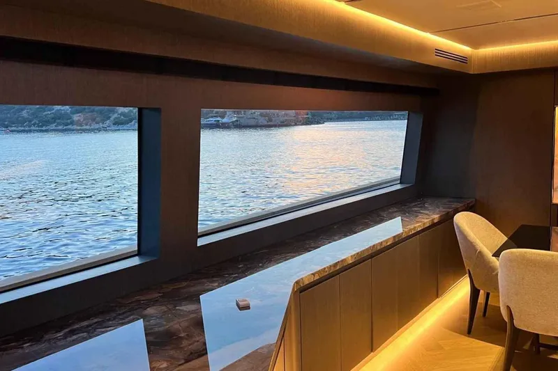  Yacht Photos Pics Luxurious interior of 1985 Heesen Pleasure Vessel with large windows overlooking serene water.