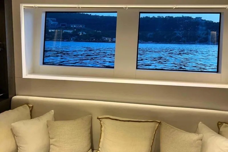  Yacht Photos Pics Interior view from 1985 Heesen Pleasure Vessel, showcasing scenic water and shoreline through windows.