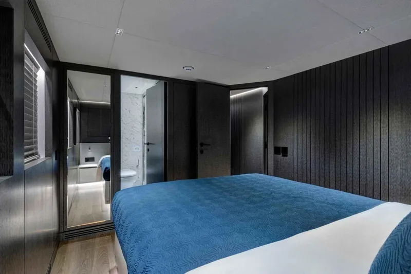  Yacht Photos Pics Luxurious bedroom interior on 1985 Heesen Pleasure Vessel with modern design and blue bedding.