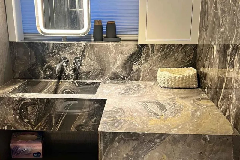  Yacht Photos Pics Luxurious marble bathroom on 1985 Heesen Pleasure Vessel, featuring modern fixtures and elegant design.