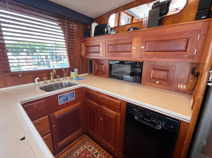 Angus III Yacht Photos Pics Luxurious wooden kitchen interior of 1998 Alden 56 PHMY yacht with sink and appliances.