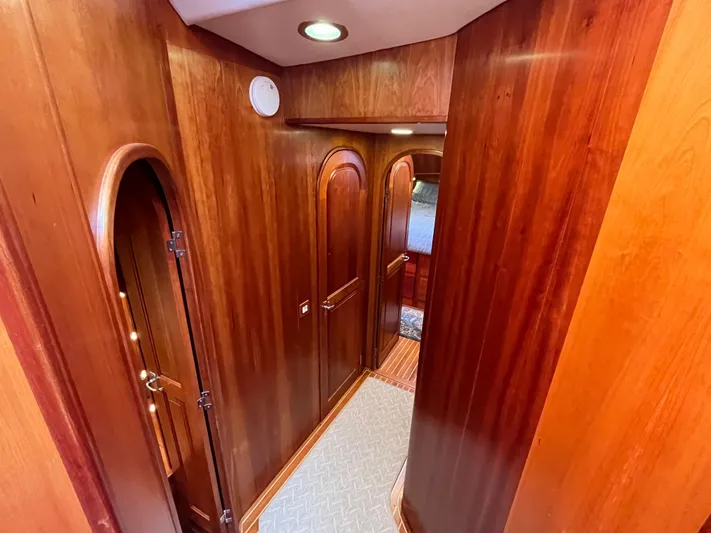 Angus III Yacht Photos Pics Wood-paneled hallway inside 1998 Alden 56 PHMY yacht, featuring elegant arched doors.