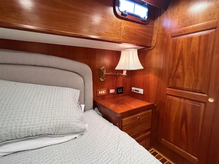 Angus III Yacht Photos Pics Luxurious wooden cabin interior of 1998 Alden 56 PHMY yacht with cozy bed and lamp.