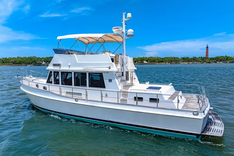 Grazie Yacht Photos Pics 2008 Grand Banks 47 Classic yacht cruising on a sunny day with a lighthouse in the background.
