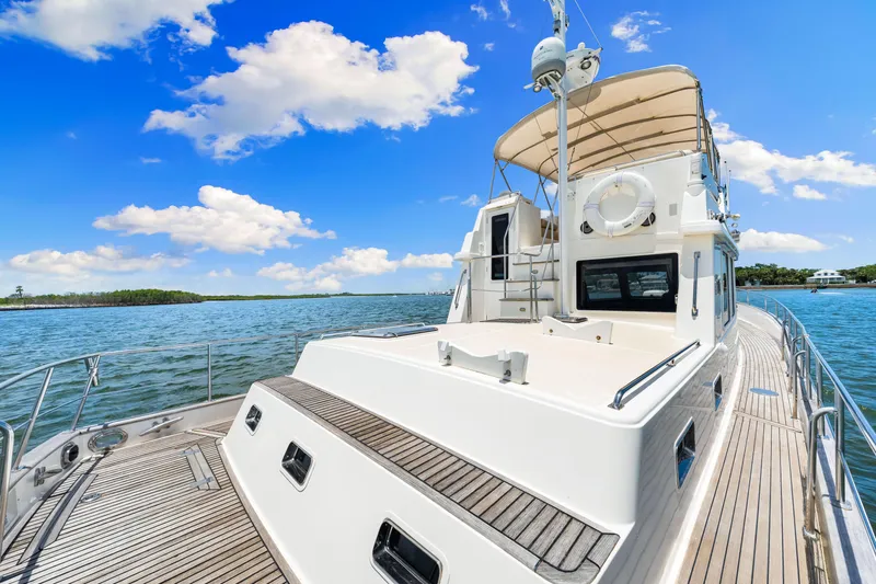 Grazie Yacht Photos Pics 2008 Grand Banks 47 Classic yacht on calm waters under a bright blue sky.