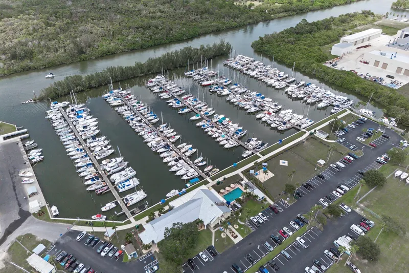 Cocoa Bella Yacht Photos Pics Aerial view of a marina with numerous boats docked, surrounded by lush greenery.