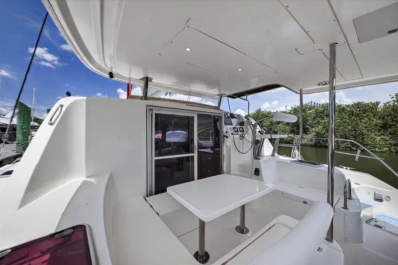 Cocoa Bella Yacht Photos Pics 2011 Leopard 38 catamaran cockpit with seating, table, and helm station under a clear sky.