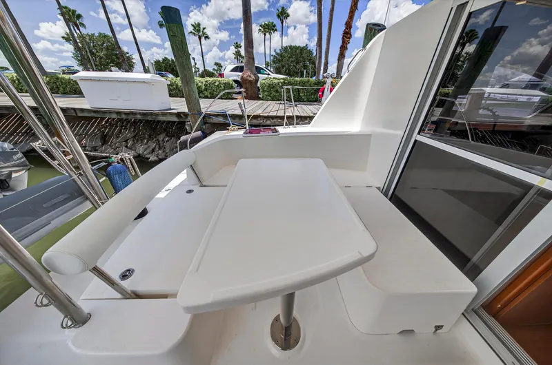 Cocoa Bella Yacht Photos Pics Outdoor seating area on a 2011 Leopard 38 catamaran, featuring a sleek white table.