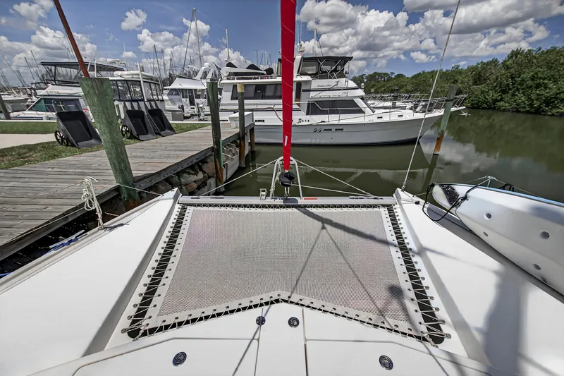 Cocoa Bella Yacht Photos Pics 2011 Leopard 38 catamaran docked at marina, surrounded by other boats under a cloudy sky.