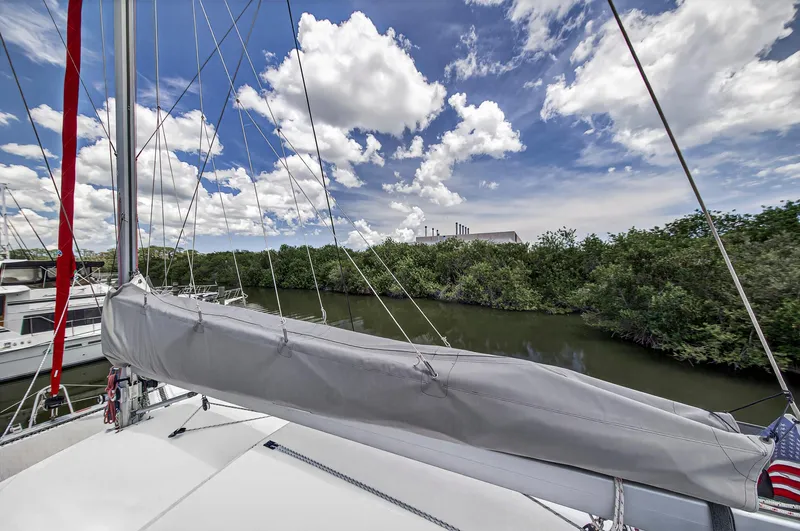 Cocoa Bella Yacht Photos Pics Sailboat Leopard 38, 2011 model, docked near lush greenery under a vibrant sky.