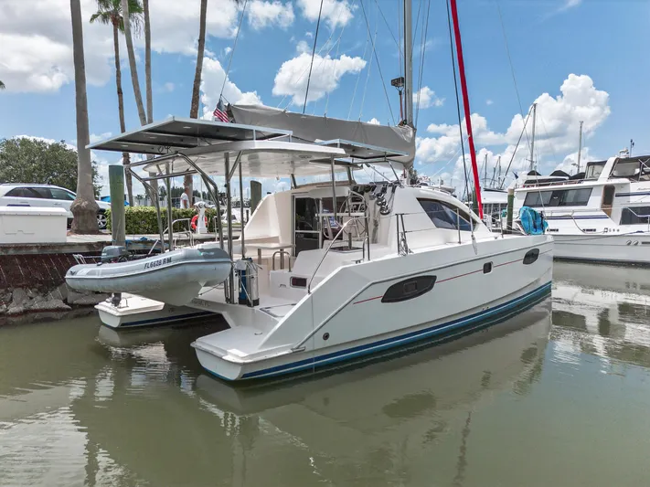 Cocoa Bella Yacht Photos Pics 2011 Leopard 38 catamaran docked in marina, clear sky, palm trees, and other boats visible.