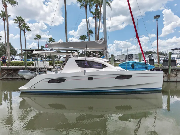 Cocoa Bella Yacht Photos Pics 2011 Leopard 38 catamaran docked, surrounded by palm trees and clear skies.