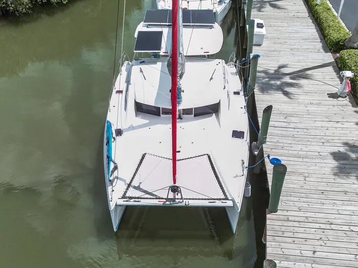 Cocoa Bella Yacht Photos Pics Aerial view of a 2011 Leopard 38 catamaran docked by a wooden pier.