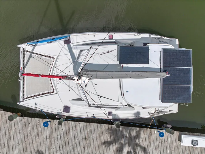 Cocoa Bella Yacht Photos Pics Overhead view of a 2011 Leopard 38 catamaran docked, featuring solar panels and a red sail.