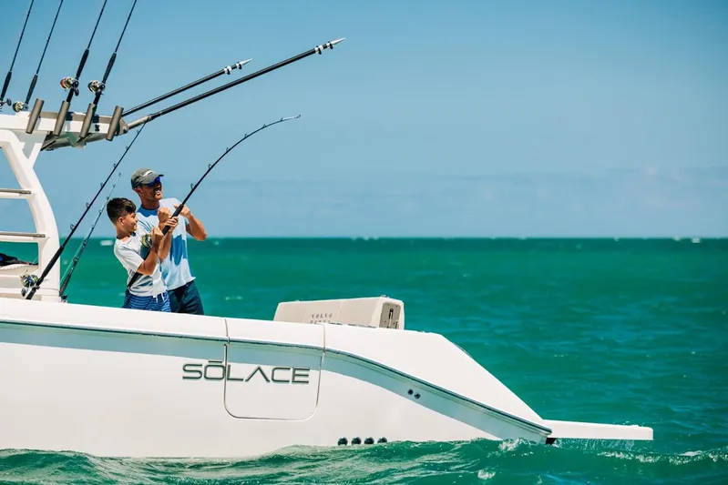Game Changer Yacht Photos Pics Two people fishing on a 2022 Solace 415 CS boat in the ocean.