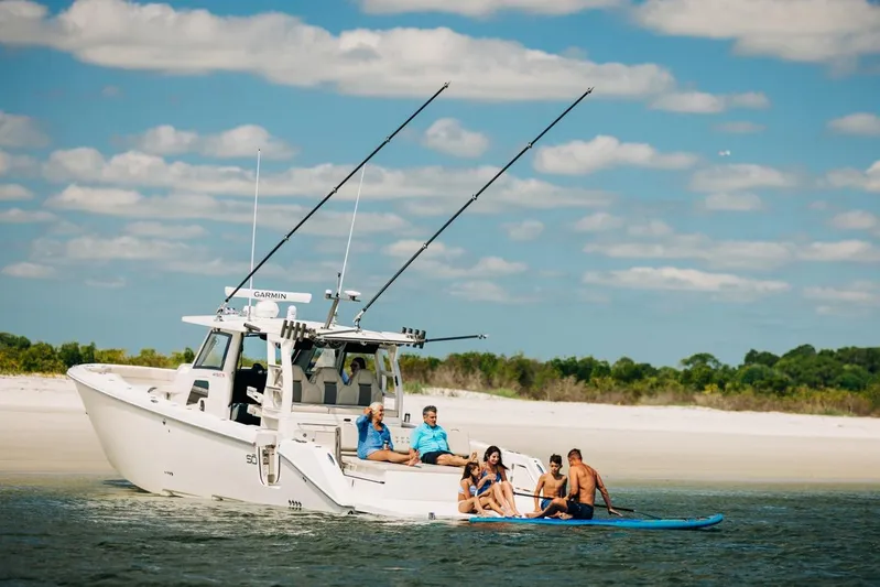 Game Changer Yacht Photos Pics 2022 Solace 415 CS boat near beach with people enjoying water activities.