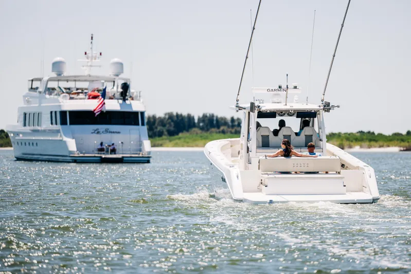 Game Changer Yacht Photos Pics 2022 Solace 415 CS boat cruising near a luxury yacht on a sunny day.