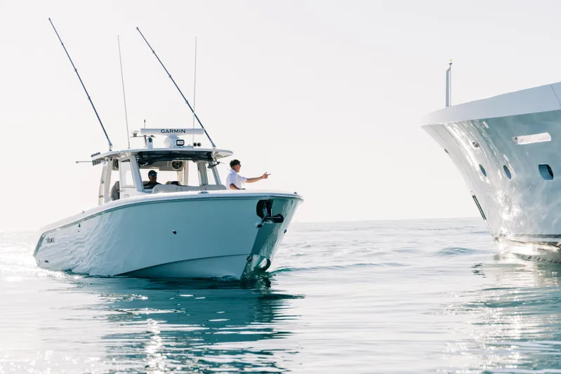 Game Changer Yacht Photos Pics 2022 Solace 415 CS boat on calm water near a larger vessel.