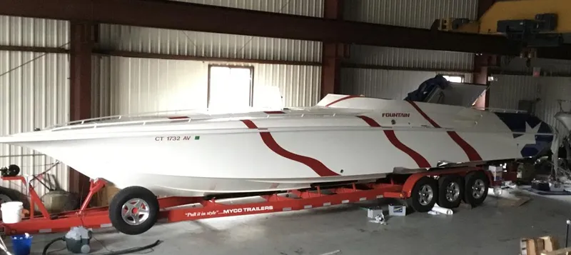  Yacht Photos Pics 1998 Fountain 42 Lightning speedboat on trailer in warehouse, red and white design.