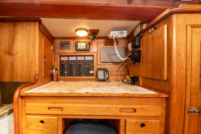 Aleyah Yacht Photos Pics Navigation station of 1984 Hank Hinckley OC42 sailboat with wooden cabinetry and electronic equipment.