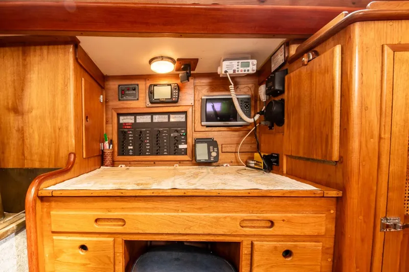 Aleyah Yacht Photos Pics Navigation station in 1984 Hank Hinckley OC42 sailboat with wooden cabinetry and communication equipment.