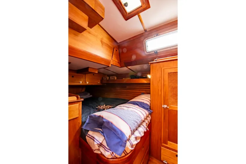 Aleyah Yacht Photos Pics Cozy wooden cabin interior of 1984 Hank Hinckley OC42 sailboat with striped bedding.