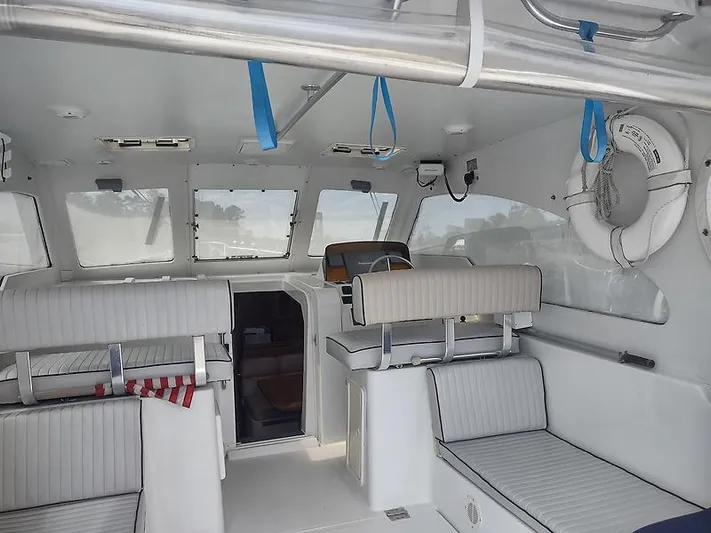 Aweigh Yacht Photos Pics Interior of 2001 Mainship Pilot 34 Sedan with white seating and life preserver.