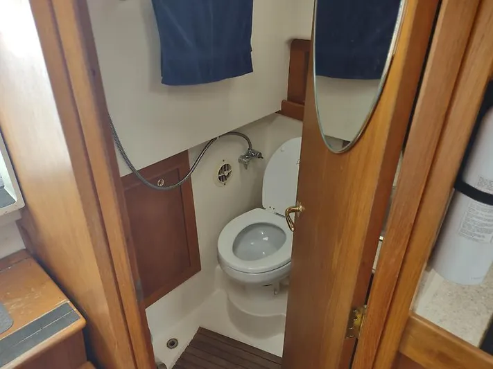 Aweigh Yacht Photos Pics 2001 Mainship Pilot 34 Sedan bathroom with wooden accents and compact design.