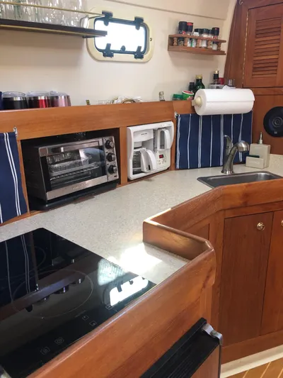 Aweigh Yacht Photos Pics 2001 Mainship Pilot 34 Sedan kitchen with appliances and wooden cabinetry.