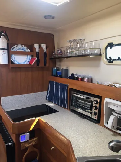 Aweigh Yacht Photos Pics 2001 Mainship Pilot 34 Sedan kitchen with appliances and storage shelves.