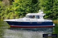 Nimbus 310 Coupe 2000 boat cruising on a serene river, surrounded by lush greenery.