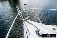 Bow of 2000 Nimbus 310 Coupe boat with stainless steel railings on water.