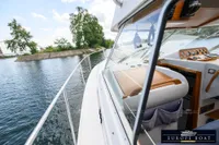 Nimbus 310 Coupe boat cruising on a serene waterway, showcasing its sleek design and cockpit.