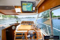 Interior view of 2000 Nimbus 310 Coupe boat cockpit with navigation system and wooden dashboard.
