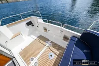 Spacious deck of 2000 Nimbus 310 Coupe with blue seating and wooden flooring.