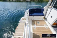Nimbus 310 Coupe 2000 boat deck with seating, overlooking calm water.