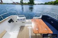 Nimbus 310 Coupe boat deck with wooden table, scenic water view, 2000 model.