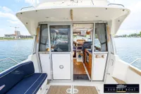 Nimbus 310 Coupe 2000 model, interior view with seating and helm, on a calm waterway.