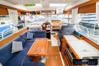 Interior of a 2000 Nimbus 310 Coupe boat with wooden accents and blue seating.