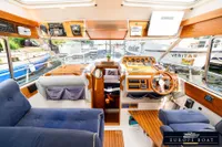Interior of 2000 Nimbus 310 Coupe boat with wooden dashboard and blue seating.