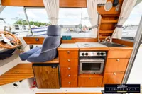 Interior of 2000 Nimbus 310 Coupe boat with kitchen and steering area.