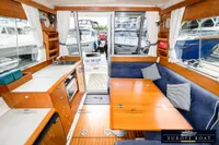 Interior of 2000 Nimbus 310 Coupe with wooden dining area and kitchenette.
