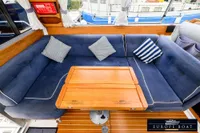 Interior of 2000 Nimbus 310 Coupe with blue seating and wooden table.