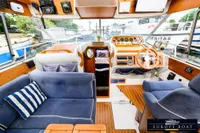 Interior of 2000 Nimbus 310 Coupe boat with wooden dashboard and blue seating.