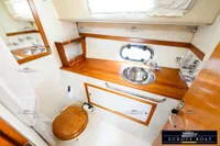 Luxurious bathroom in 2000 Nimbus 310 Coupe with wooden accents and stainless steel sink.