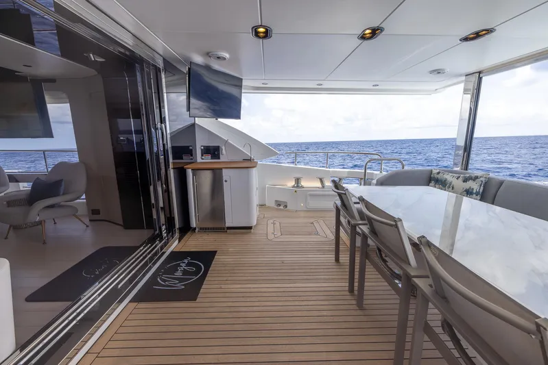 Captain Morgan II Yacht Photos Pics Luxurious Azimut Grande 27 METRI yacht deck with ocean view, featuring elegant seating and dining area.