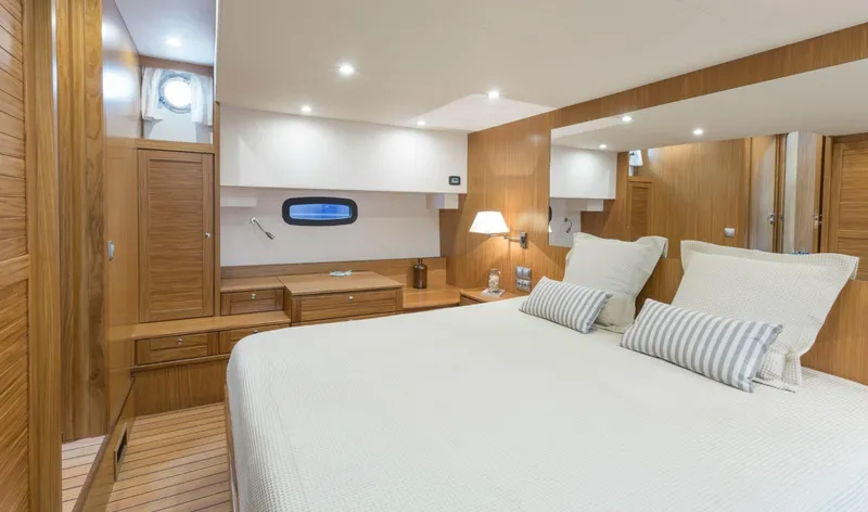  Yacht Photos Pics Luxurious cabin interior of 2026 Sasga Yachts 55, featuring elegant wood finishes and cozy bedding.