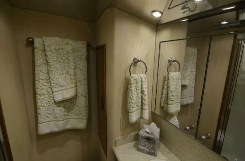 Burnin Daylight Yacht Photos Pics Luxurious bathroom interior of 2006 Hatteras 50 Convertible yacht with elegant towels and lighting.